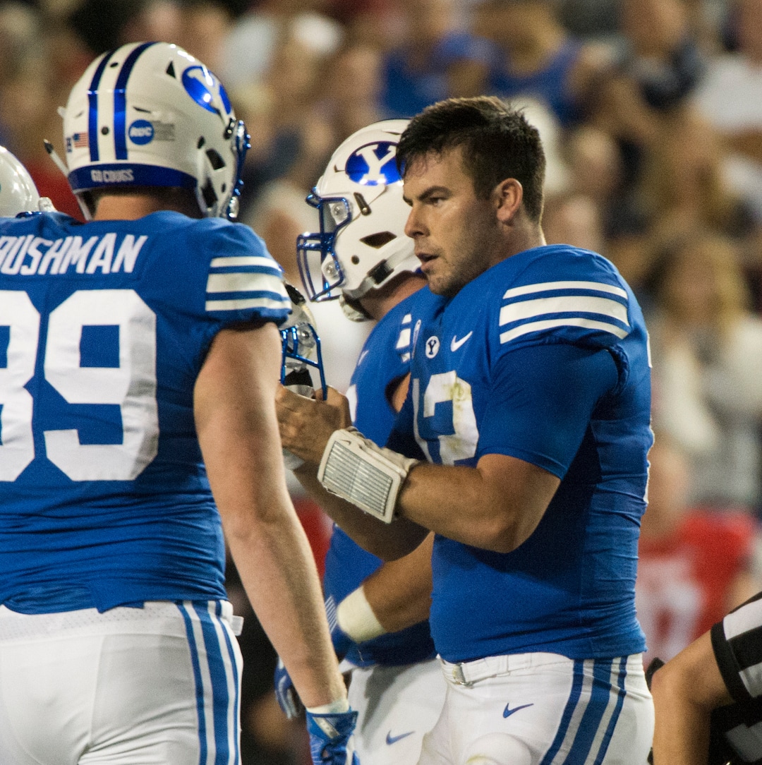 (Rick Egan  |  The Salt Lake Tribune)   Brigham Young Cougars quarterback Tanner Mangum (12)  put this helmet back on , after being hit by Utah Uteslinebacker Sunia Tauteoli (10) in football action BYU vs Utah, at Lavell Edwards Stadium in Provo, Saturday,  FItts was called for targeting on the play. September 9, 2017.