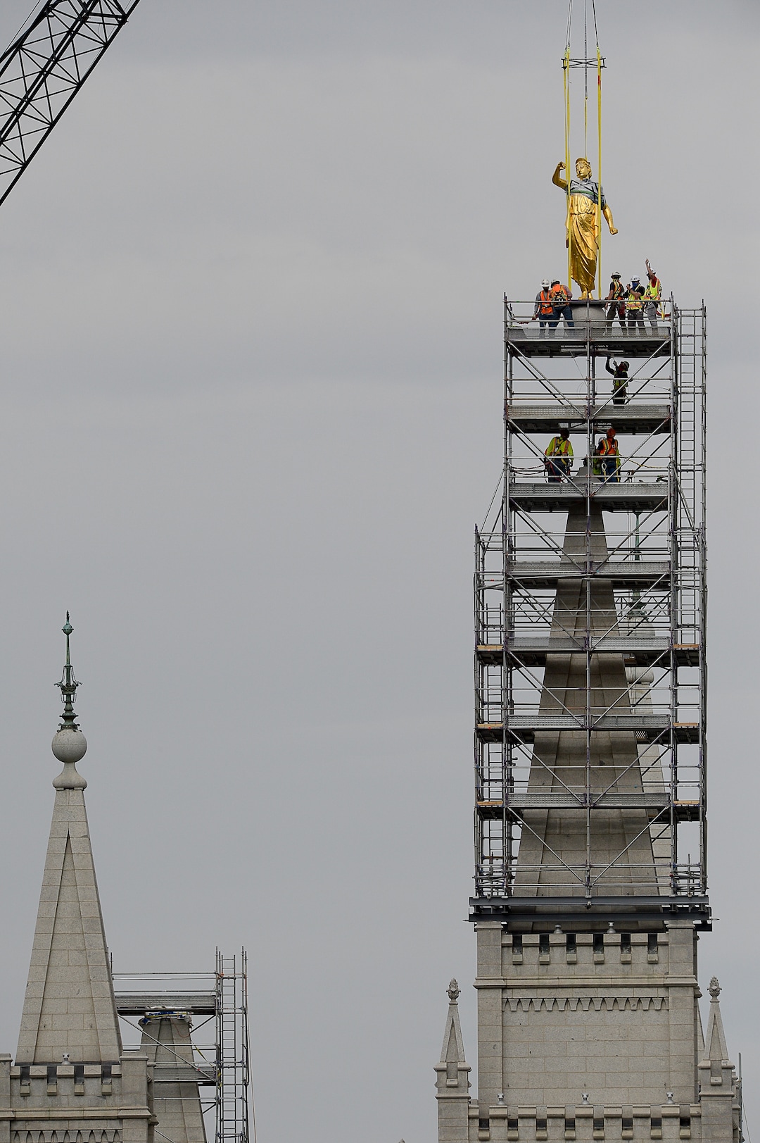 (Francisco Kjolseth  |  The Salt Lake Tribune) Crews work to remove the Angel Moroni statue atop the Salt Lake Temple of The Church of Jesus Christ of Latter-day Saints on Monday, May 18, 2020. The temple closed in December for seismic upgrades and sustained minor damager during the March 18, 2020, magnitude 5.7 earthquake when the trumpet held by the angel fell off and several smaller spire stones were displaced.