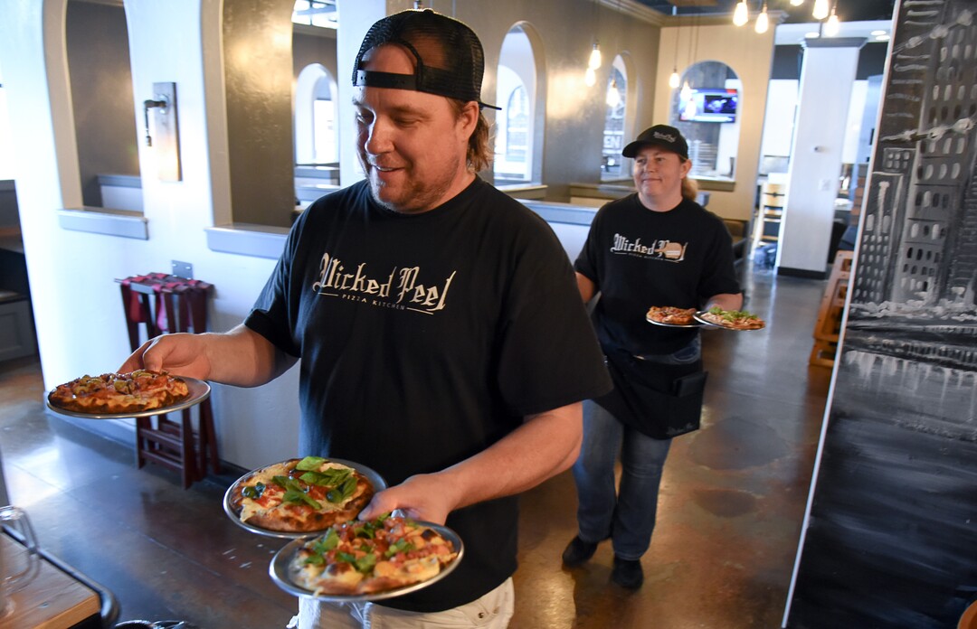 (Francisco Kjolseth  |  The Salt Lake Tribune)  Charlie Wallwork and his wife Marylee, owners at Wicked Peel Pizza Kitchen in Riverton, deliver the lunch special, a kids sized pizza with a side salad.