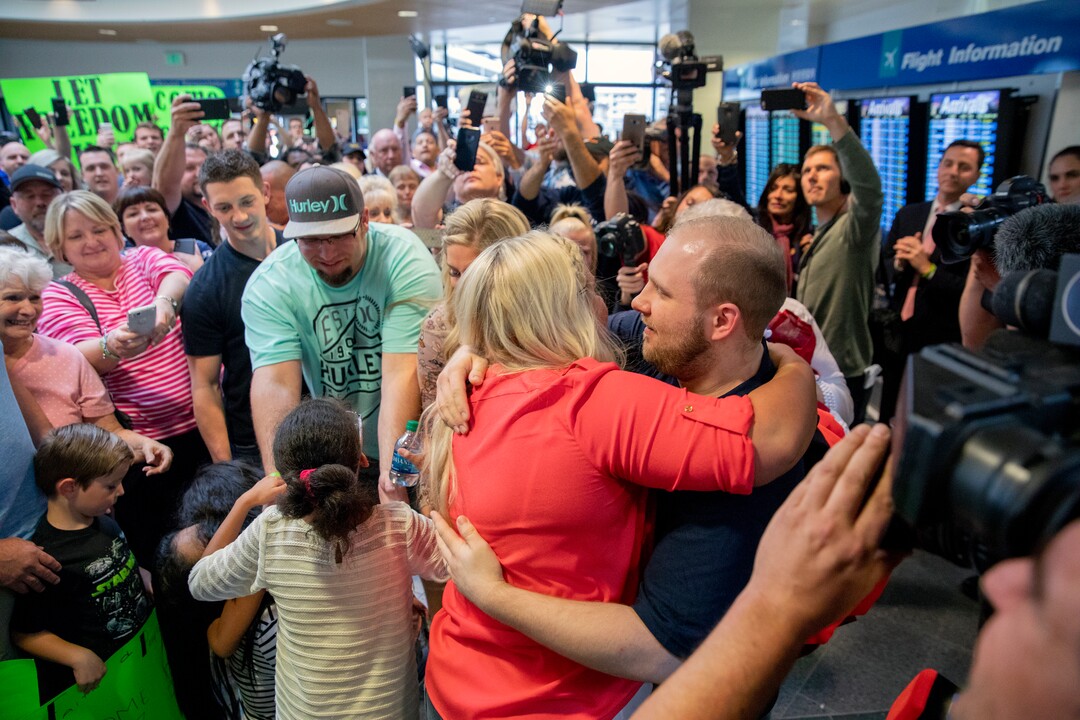 Josh Holt, right, is greeted by family and friends upon returning to Salt Lake City on Monday, May 28, 2018, after receiving medical care and visiting President Donald Trump in Washington. Holt was freed this weekend after being held in a Venezuelan jail for nearly two years. (AP Photo/Kim Raff)