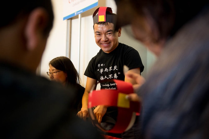 (Trent Nelson | The Salt Lake Tribune)  Xi Qiang helps children construct Chinese hats at the Chinese New Year Celebration at the County Library's Viridian Event Center in West Jordan, Saturday Feb. 17, 2018.