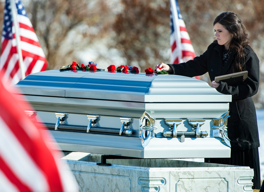 (Rick Egan  |  The Salt Lake Tribune)   McKenzie Fuchigami, puts a flower on the casket in the Brigham City Cemetery, after the funeral for her husband Kirk T. Fuchigami Jr. who was killed in Afghanistan, Monday, Dec. 9, 2019.