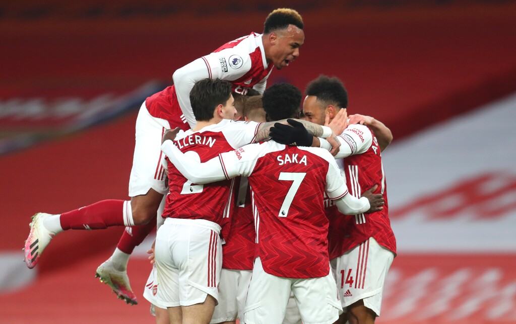 Arsenal players celebrate after Arsenal's Pierre-Emerick Aubameyang, right, scored his side's opening goal during the English Premier League soccer match between Arsenal and Leeds United at the Emirates stadium in London, England, Sunday, Feb. 14, 2021. (Catherine Ivill/Pool via AP)