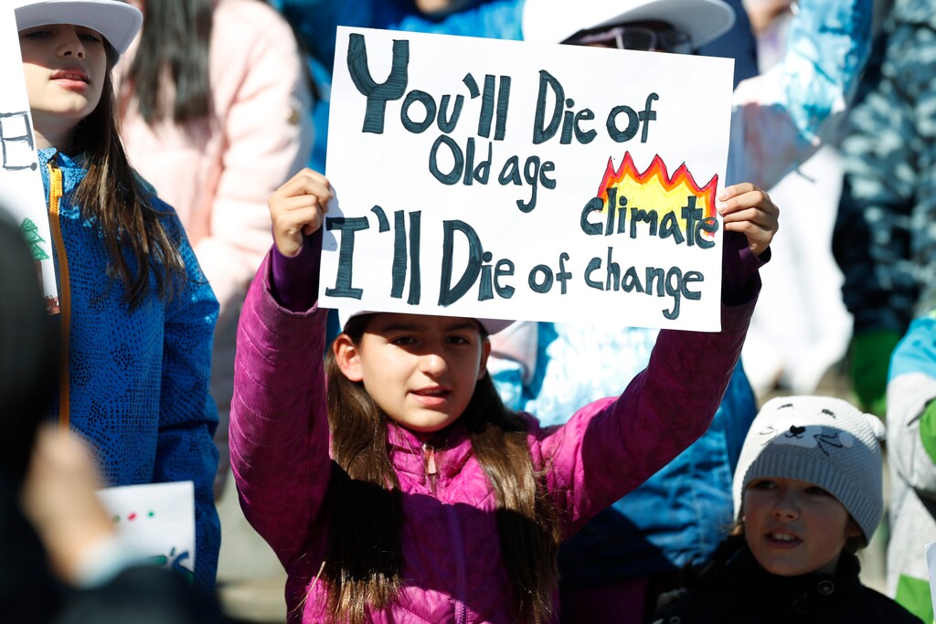 (David Zalubowski | AP file photo) Ten-year-old Harper Phillips of Denver waves a placard as Swedish climate activist Greta Thunberg speaks to several thousand people at a climate strike rally on Friday, Oct. 11, 2019, in Denver. The rally was staged in Denver's Civic Center Park.