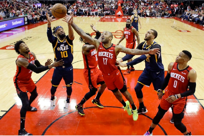 Utah Jazz guard Mike Conley (10) and Houston Rockets forward P.J. Tucker (17) vie for a rebound during the first half of an NBA basketball game, Sunday, Feb. 9, 2020, in Houston. (AP Photo/Eric Christian Smith)