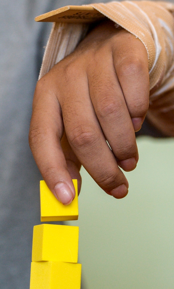 (Leah Hogsten  |  The Salt Lake Tribune) Stak works on finger dexterity by stacking blocks during his daily therapy session. Audrick “Stak” Afatasi is fighting to regain movement in his lower body after being paralyzed at a trampoline park on March 15, 2019.
