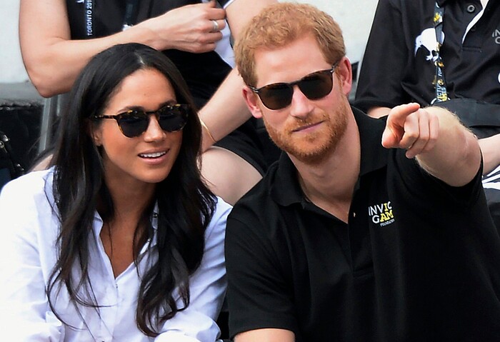 FILE - In this Monday, Sept. 25, 2017 file photo, Britain's Prince Harry and his girlfriend Meghan Markle attend the wheelchair tennis competition during the Invictus Games in Toronto. Palace officials announced Monday Nov. 27, 2017, Prince Harry and Meghan Markle are engaged, and will marry in the spring. (Nathan Denette/The Canadian Press via AP, File)