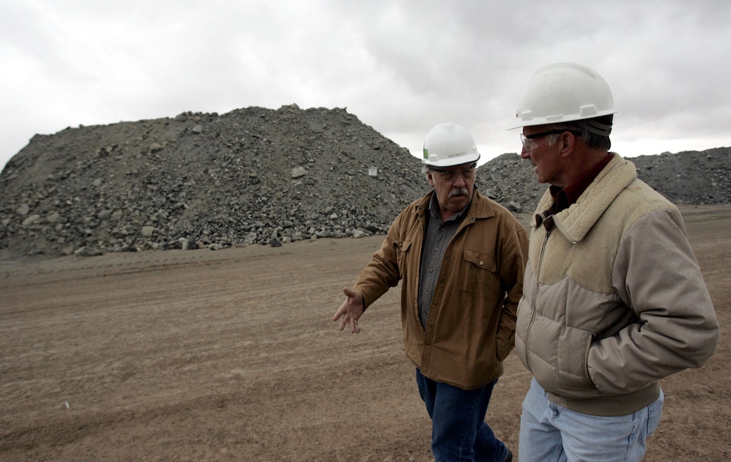 (Tribune File Photo) With piles of uranium ore behind them, Rich Bartlett, left, and Harold Roberts discuss the operations of the White Mesa mill that processes uranium outside Blanding, Utah, in this May 23, 2007 file photo.