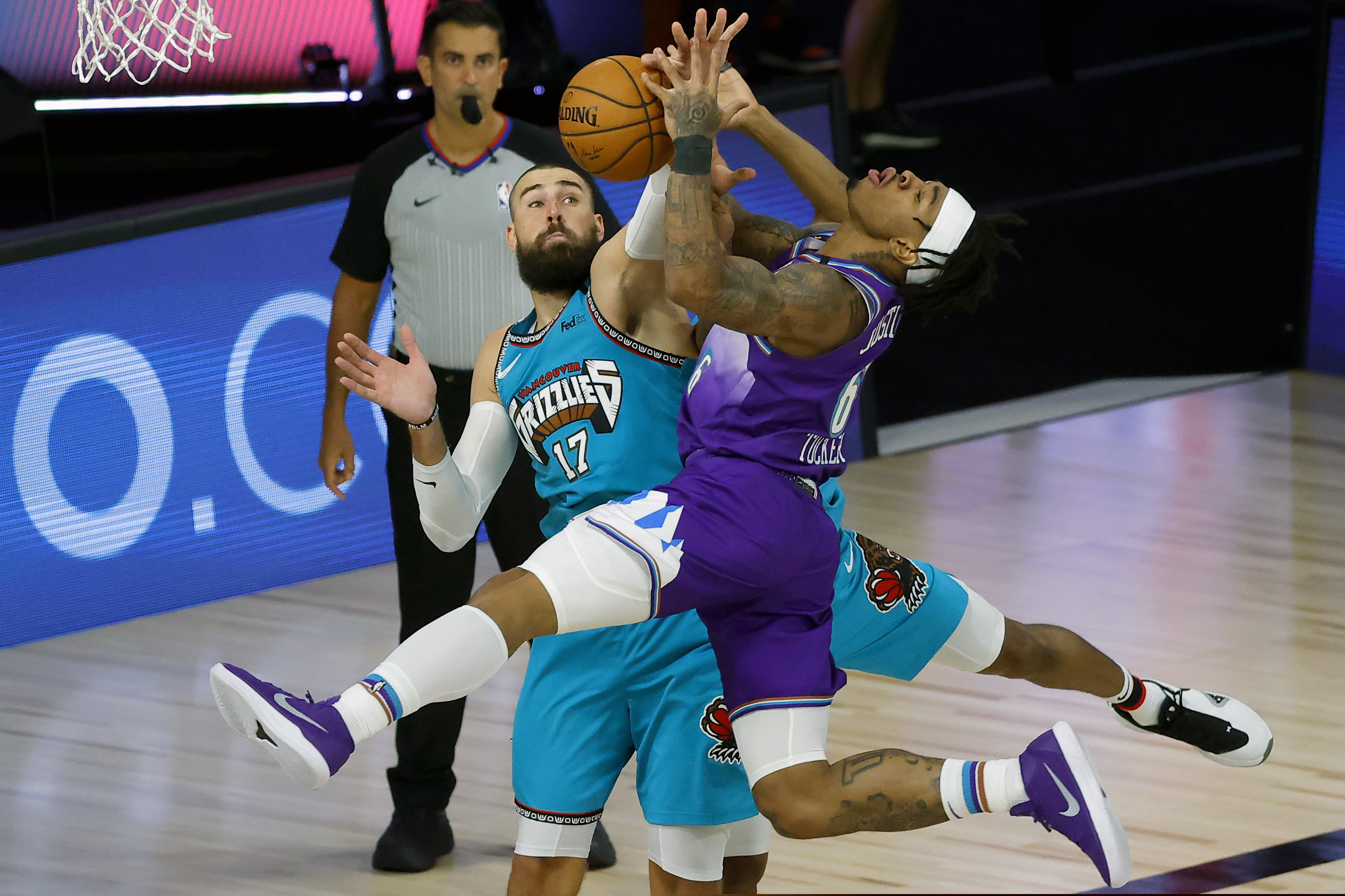 Utah Jazz's Rayjon Tucker (6) draws a foul from Memphis Grizzlies' De'Anthony Melton (0) as Memphis Grizzlies' Jonas Valanciunas (17) defends during the second half of an NBA basketball game Wednesday, Aug. 5, 2020, in Lake Buena Vista, Fla. (Kevin C. Cox/Pool Photo via AP)