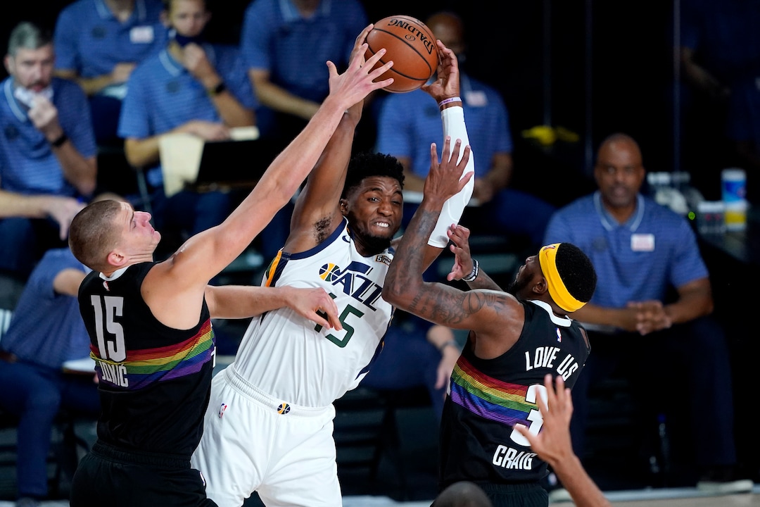 (Ashley Landis | AP) Utah Jazz's Donovan Mitchell (45) passes as Denver Nuggets' Nikola Jokic (15) and Torrey Craig (3) defend during the first half of an NBA basketball first round playoff game, Wednesday, Aug. 19, 2020, in Lake Buena Vista, Fla.