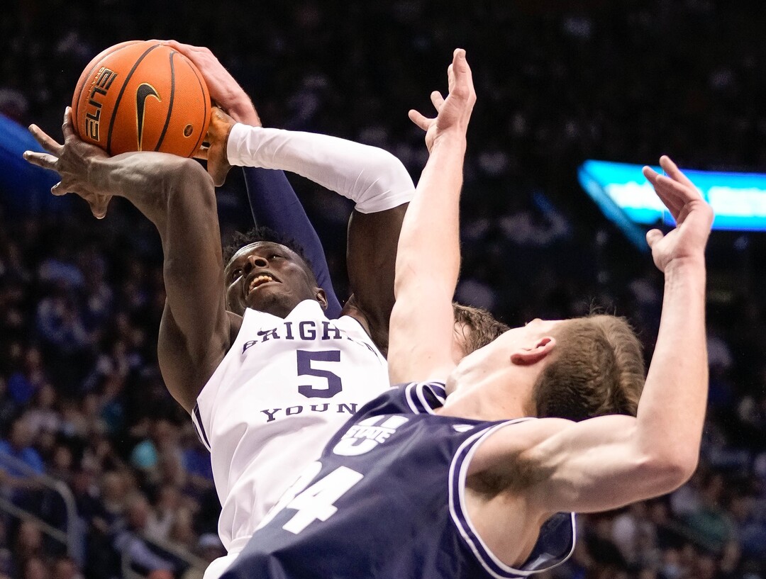 (Francisco Kjolseth | The Salt Lake Tribune) Brigham Young Cougars forward Gideon George (5) feels the pressure on his way to the basket in basketball action between the Brigham Young Cougars and the Utah State Aggies at the Marriott Center in Provo, Wednesday, Dec. 8, 2021.