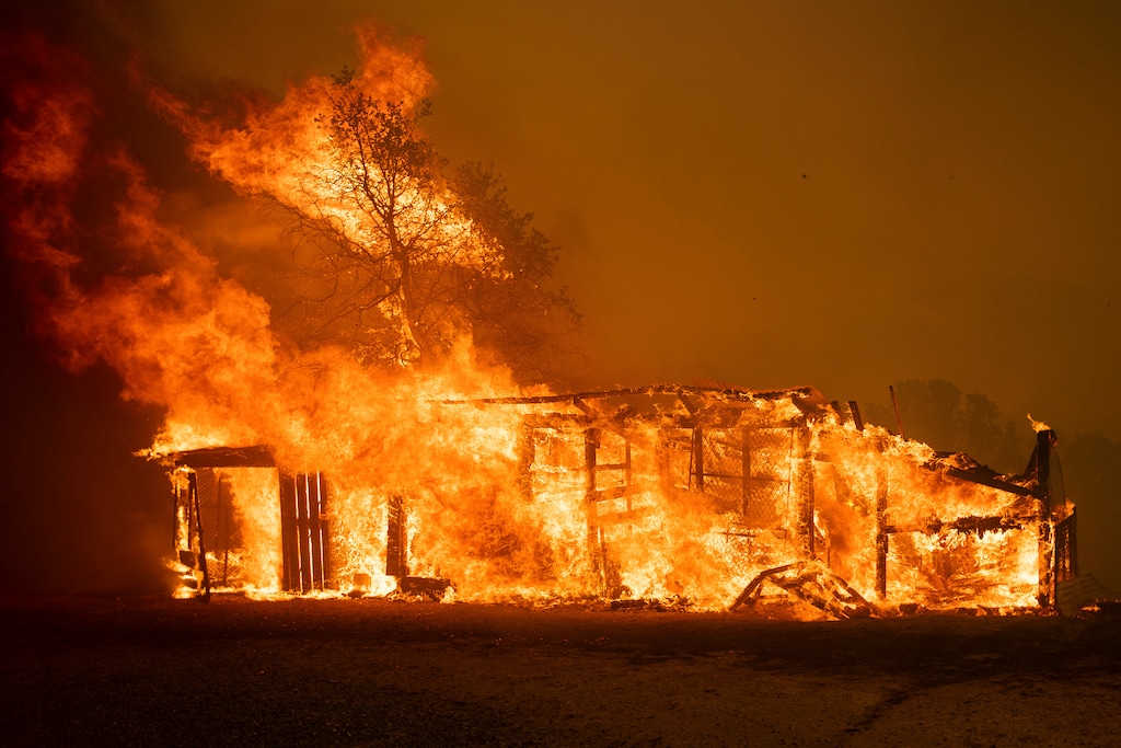 An outbuilding burns on Dessie Drive as the River Fire tears through Lakeport, Calif., on Tuesday, July 31, 2018. (AP Photo/Noah Berger)