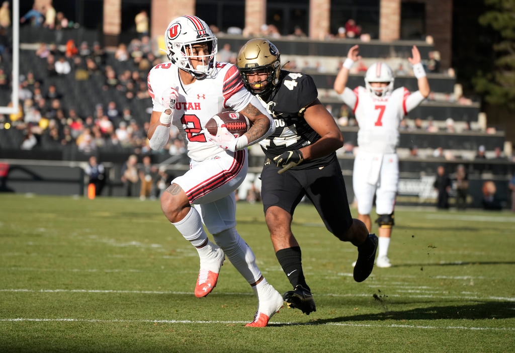Utah running back Micah Bernard (2) runs past Colorado linebacker Devin Grant (44) for a touchdown as Utah quarterback Cameron Rising (7) gestures in the first half of an NCAA college football game Saturday, Nov. 26, 2022, in Boulder, Colo. (AP Photo/David Zalubowski)