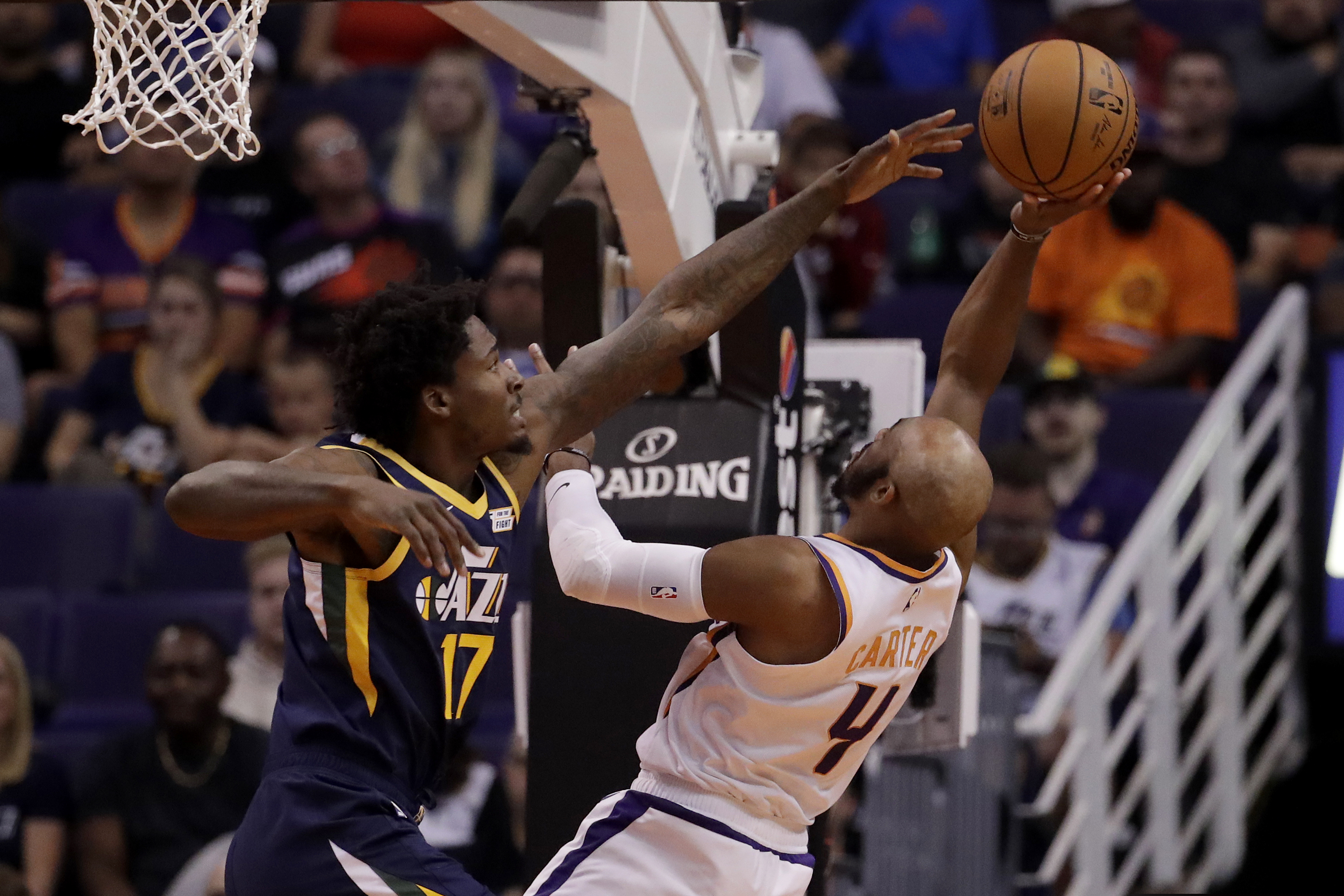 Phoenix Suns guard Jevon Carter (4) shoots over Utah Jazz center Ed Davis (17) during the first half of an NBA basketball game, Monday, Oct. 28, 2019, in Phoenix. (AP Photo/Matt York)
