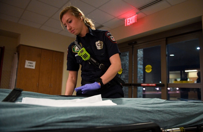 In this Jan. 19, 2018, photo, Lehi firefighter and paramedic Aubrey Freiberg makes the bed of the ambulance gurney after she and fellow firefighters responded to a medical call at Mountain Point Medical Center in Lehi, Utah. (Isaac Hale/The Daily Herald via AP)