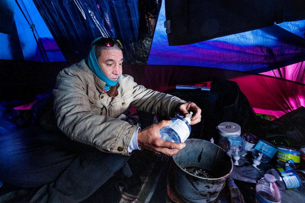 (Rick Egan | The Salt Lake Tribune) Tony Lambert puts hand sanitizer in a bucket he uses to keep his tent warm. While trying to find a safe place to stay warm this winter, he's been pushed from one location to another during camp abatements by the health department and Salt Lake City Police. Photo taken on Friday, Feb. 4, 2022.