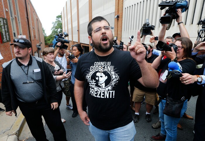 FILE- In this Monday, Aug. 14, 2017, file photo, Matthew Heimbach, center, voices his displeasure at the media after a court hearing for James Alex Fields Jr., in front of court in Charlottesville, Va. A judge has denied bond for Fields accused of plowing his car into a crowd at a white nationalist rally. (AP Photo/Steve Helber, File)