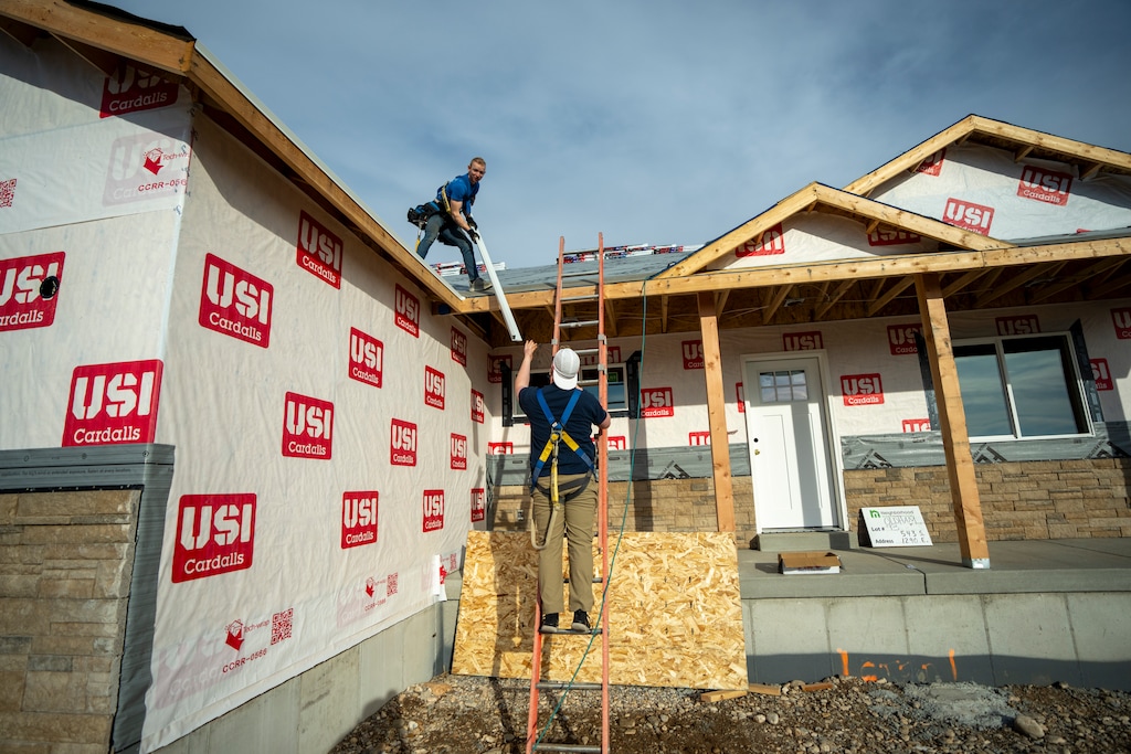 (Rick Egan | The Salt Lake Tribune)  Cade Matheson, top, and Cameron Oldham work on a home in Hyrum on Wednesday, March 4, 2026. The home is part of a rural housing initiative the federal government scaled back last month.
