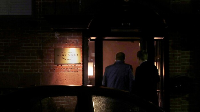 In this Dec. 10, 2019, photo two patrons walk through the barely lit, nondescript doorway leading to the Wink & Nod basement-dwelling, speakeasy-like bar in Boston. Americans are consuming more alcohol per capita now than in the time leading up to Prohibition. (AP Photo/Charles Krupa)