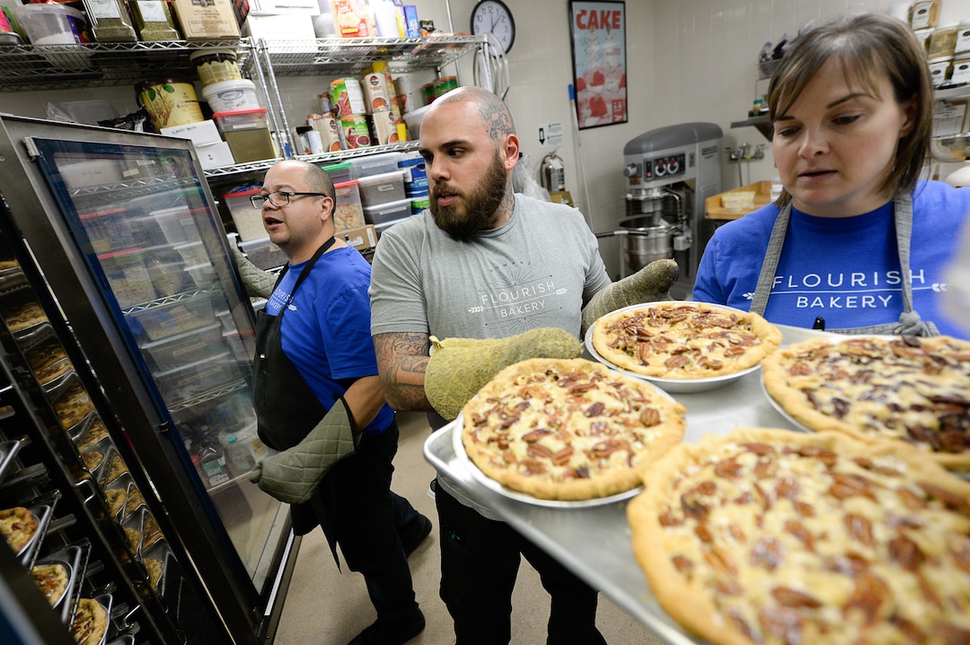 (Francisco Kjolseth  |  The Salt Lake Tribune)  Dennis Sisneros, left, an intern at Flourish Bakery joins A.J. Collette, head of operations, and Executive Director Aimee Altizer prepare a large order of pies before the Thanksgiving holiday. The non-profit bakery teaches those who have been incarcerated or recovering from substance abuse the art of baking. The skills they learn help them get a job and become financially independent. The bakery has been housed at SLCC's South City campus, but the college has said they can no longer use the space.