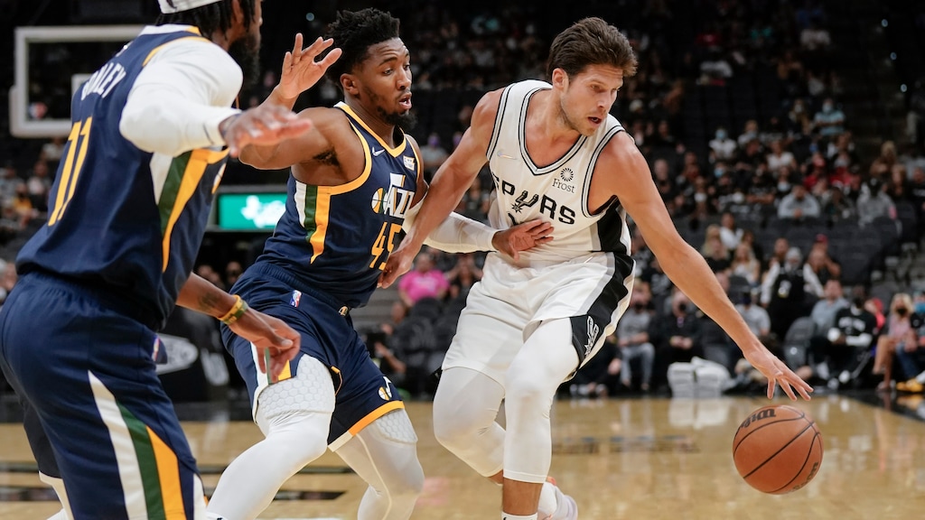 San Antonio Spurs' Doug McDermott, right, drives against Utah Jazz's Donovan Mitchell (45) and Mike Conley during the first half of a preseason NBA basketball game on Monday, Oct. 4, 2021, in San Antonio. (AP Photo/Darren Abate)