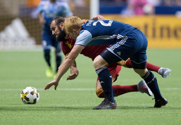 Vancouver Whitecaps' Tim Parker and Real Salt Lake's Yura Movsisyan, back, vie for the ball during the first half of an MLS soccer match Saturday, Sept. 9, 2017, in Vancouver, British Columbia. (Darryl Dyck/The Canadian Press via AP)