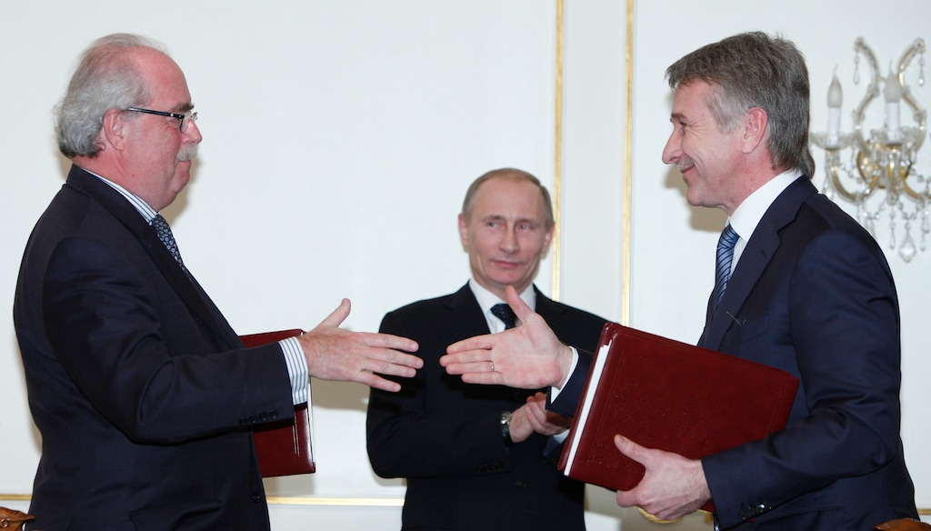 (Alexander Zemlianichenko | The Associated Press) Russian Prime Minister Vladimir Putin, center, oversees shake hands between French energy giant Total CEO Christophe de Margerie, left, and Novatek's CEO Leonid Mikhelson, right, after the signing ceremony during a meeting at the Novo-Ogaryovo residence outside Moscow,  Russia, Wednesday, March 2, 2011. The French energy company on Wednesday agreed to buy 12 percent in Russia's second-largest gas producer and buy 20 percent in a major LNG project in western Siberia.