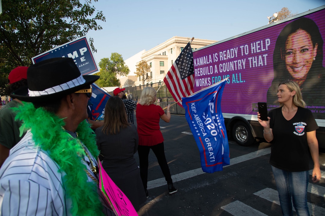 (Francisco Kjolseth  |  The Salt Lake Tribune) Supporters of President Donald Trump rally outside of Kingsbury Hall on the University of Utah campus in Salt Lake City on Wednesday, Oct. 7, 2020, during the vice presidential debates, as a mobile unit drives by with advertising for the democratic ticket.