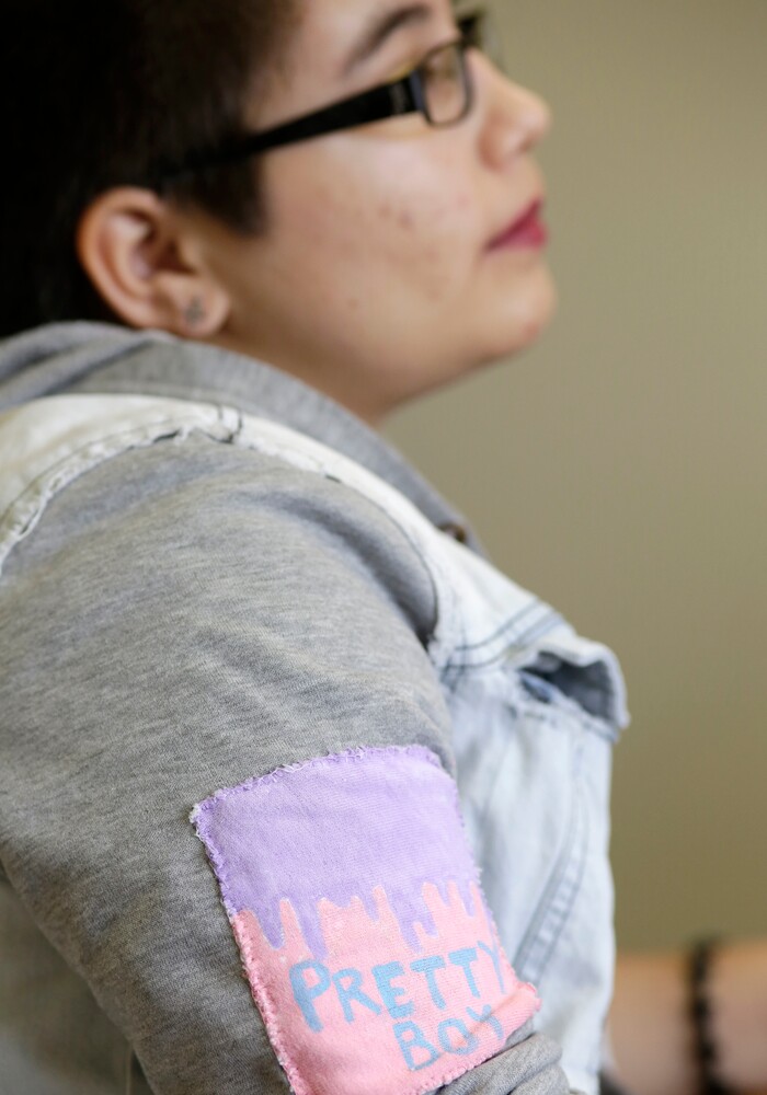 (Lynne Sladky | The Associated Press) In this Thursday, Oct. 8, 2015 photo, Theo Ramos, 14, wears a patch which reads, "Pretty Boy" as he waits for an evaluation by an endocrinologist in Miami. “When you’re 10 years old, you really shouldn’t be worried about who you are,” Theo would say years later, in a moment of reflection. “You shouldn’t be having that existential question when you’re in fifth grade. You should be worried about homework and the fifth-grade dance coming up.”