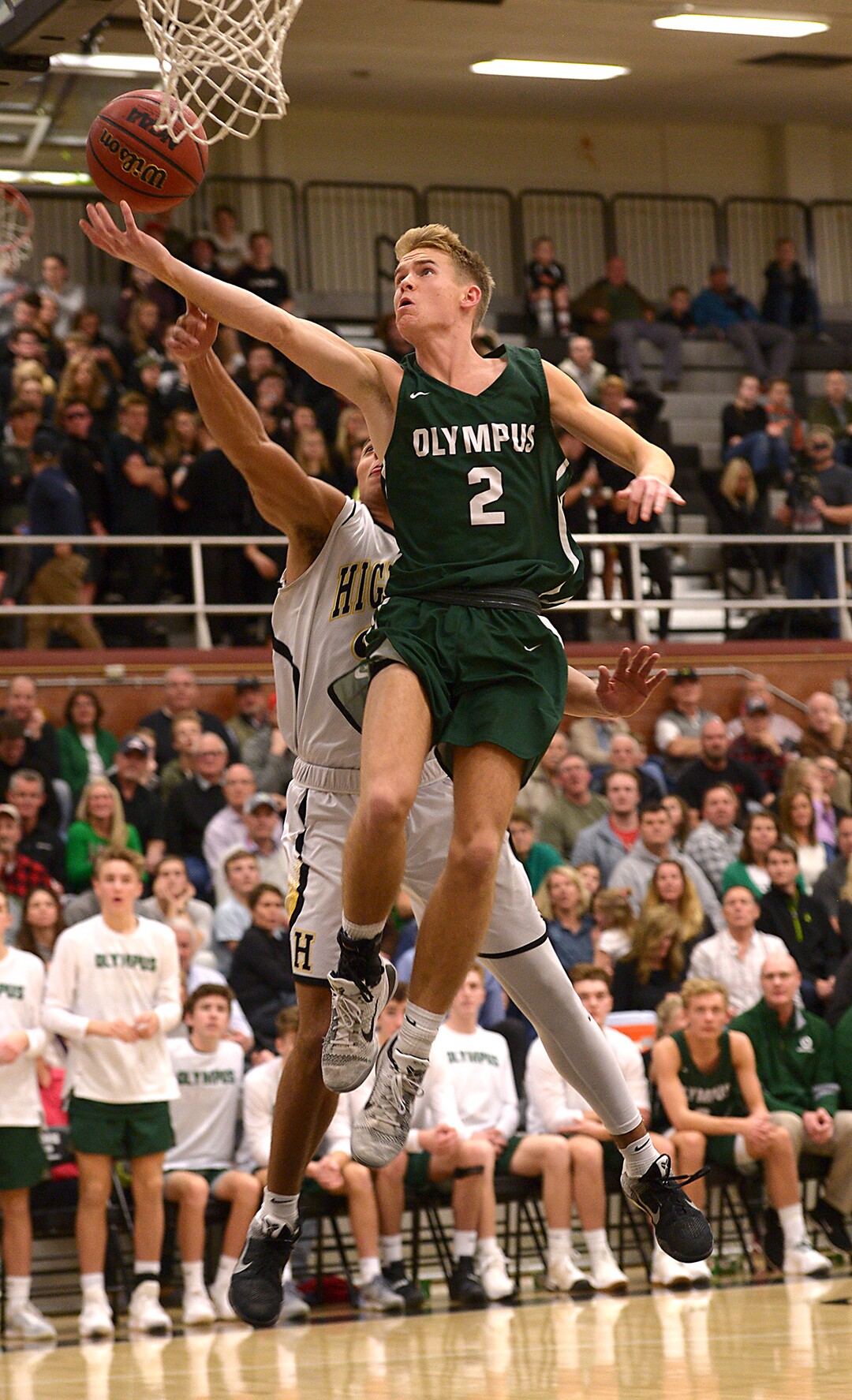 (Leah Hogsten  |  The Salt Lake Tribune)  Highland's Elijah Shelton swats away Olympus' Jacob DowDell. Olympus High School defeated Highland High School 86-54 during their basketball game, Tuesday, February 6, 2018.