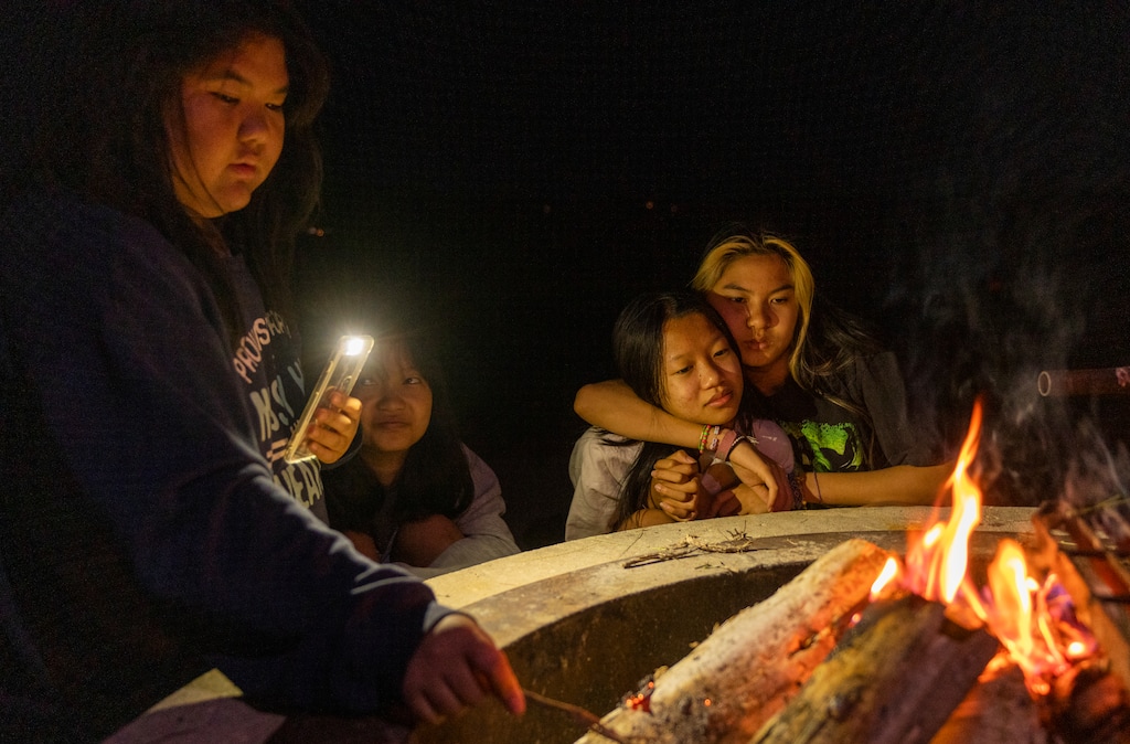 (Rick Egan | The Salt Lake Tribune) (Rick Egan | The Salt Lake Tribune) Hser Ku and Cha Wah sit by the fire while camping with their Boy Scouts troop at Jordanelle State Park on Friday, June 10, 2022.