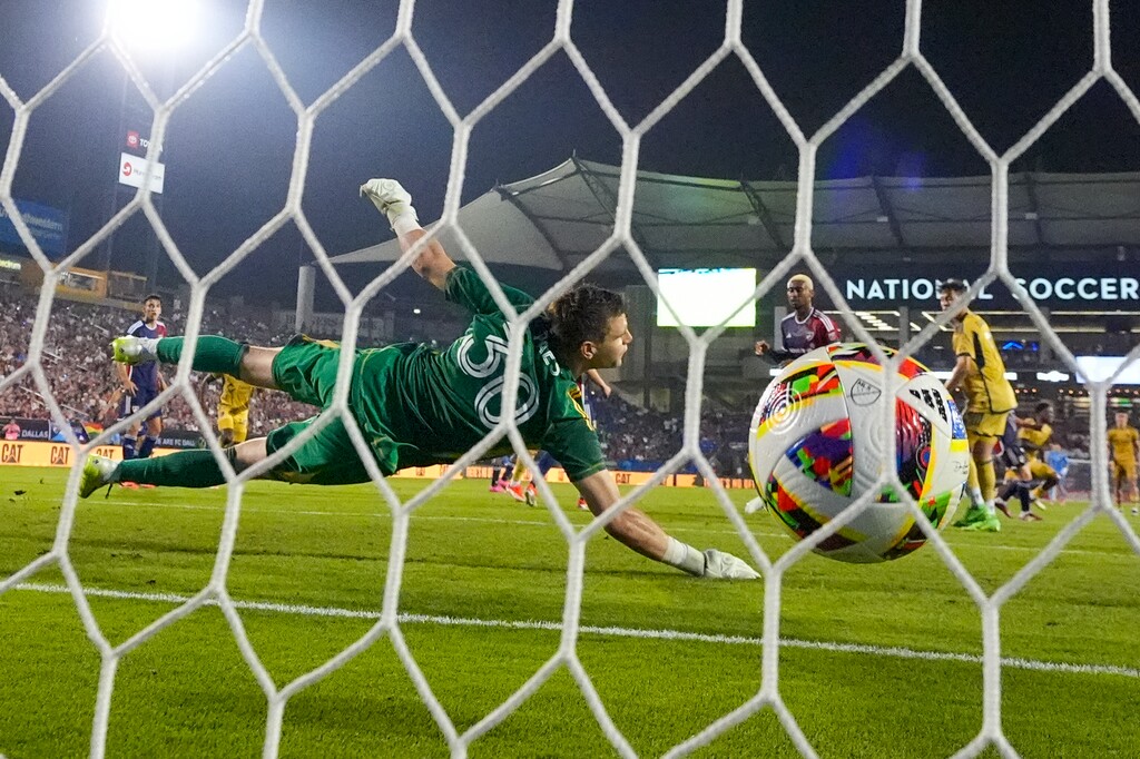 FC Dallas goalkeeper Maarten Paes (30) makes an attempt on a scoring shot by Real Salt Lake midfielder Nelson Palacio to tie the score 3-3 in injury time during the second half of an MLS soccer match, Saturday, May 25, 2024, in Frisco, Texas. The teams tied 3-3. (AP Photo/Julio Cortez)