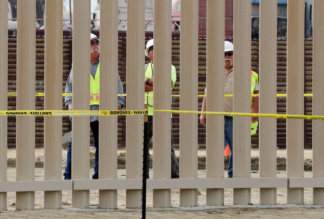(Gregory Bull | Associated Press file photo)  In this Oct. 19, 2017 file photo, crews work on a border wall prototype near the border with Tijuana, Mexico, in San Diego. A U.S. official says recent testing of prototypes of President Donald Trump's proposed wall with Mexico found their heights should stop border crossers. U.S. tactical teams spent three weeks trying to breach and scale the models in San Diego. An official with direct knowledge of the results said they point to see-through steel barriers topped by concrete as the best design. The official spoke to The Associated Press on condition of anonymity because the information is not authorized for release.