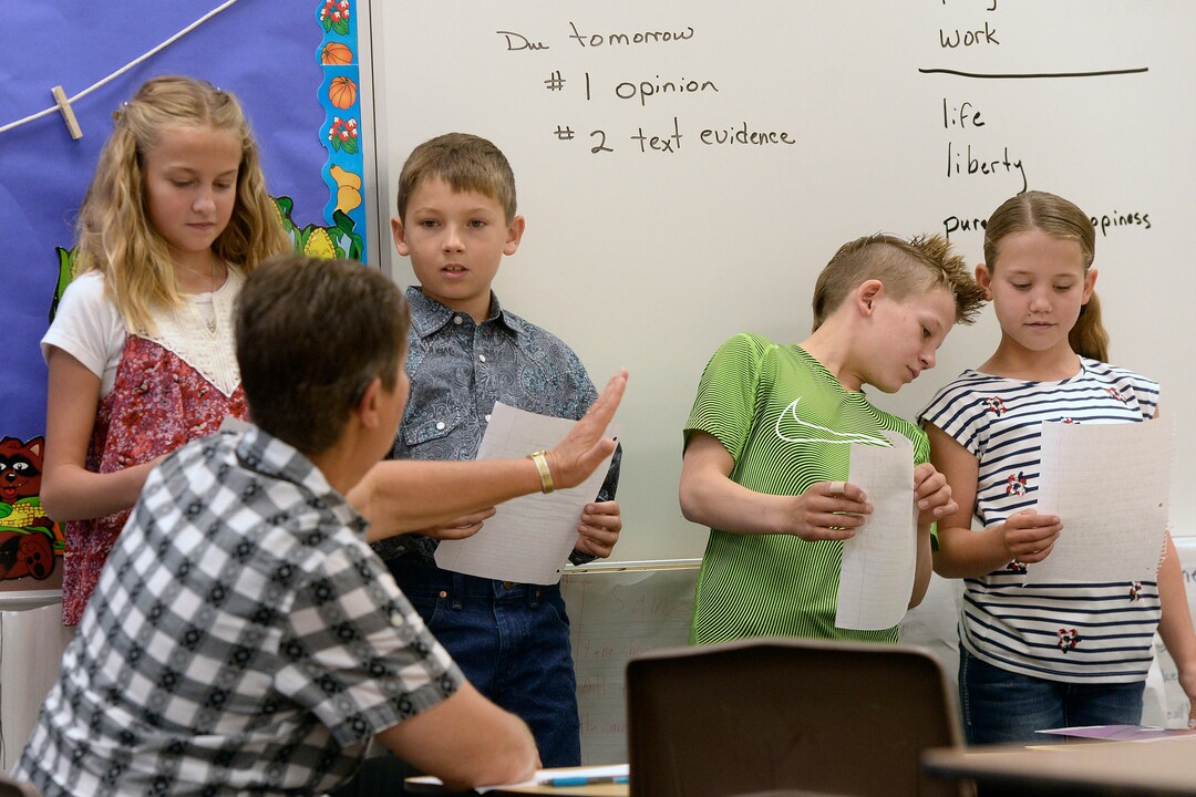 (Al Hartmann  |  The Salt Lake Tribune) Teacher's aide Holly Carter has second and third graders read aloud a paper they have written on the importance of sports in American culture at Park Valley School Wednesday August 30.  She has been a teacher's aide for 18 years.  Her mother and grandmother taught too.