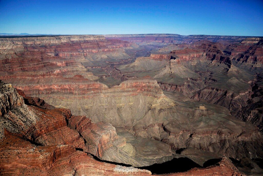 FILE - In this Oct. 5, 2013, file photo, the Grand Canyon National Park is covered in the morning sunlight as seen from a helicopter near Tusayan, Ariz. Arizona officials on Friday, Jan. 19, 2018, guaranteed that the Grand Canyon National Park will remain in full operation if Congress fails to pass a budget and a government shutdown ensues. (AP Photo/Julie Jacobson, File)