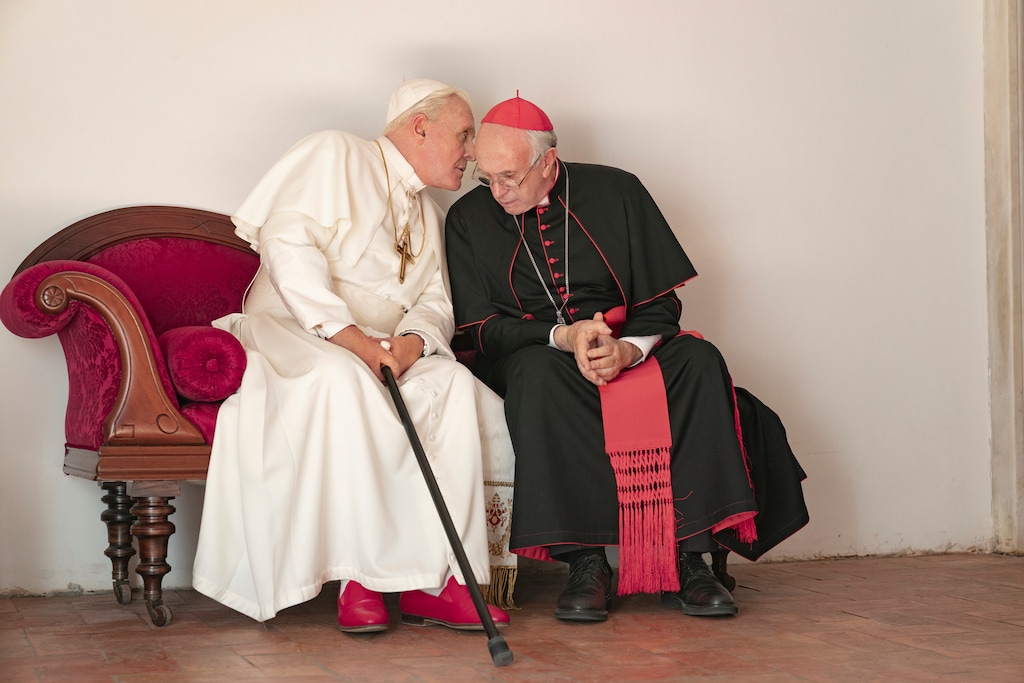 (Peter Mountain/Netflix via AP) This image released by Netflix shows Jonathan Pryce as Cardinal Bergoglio, right, and Anthony Hopkins as Pope Benedict in a scene from "The Two Popes."
