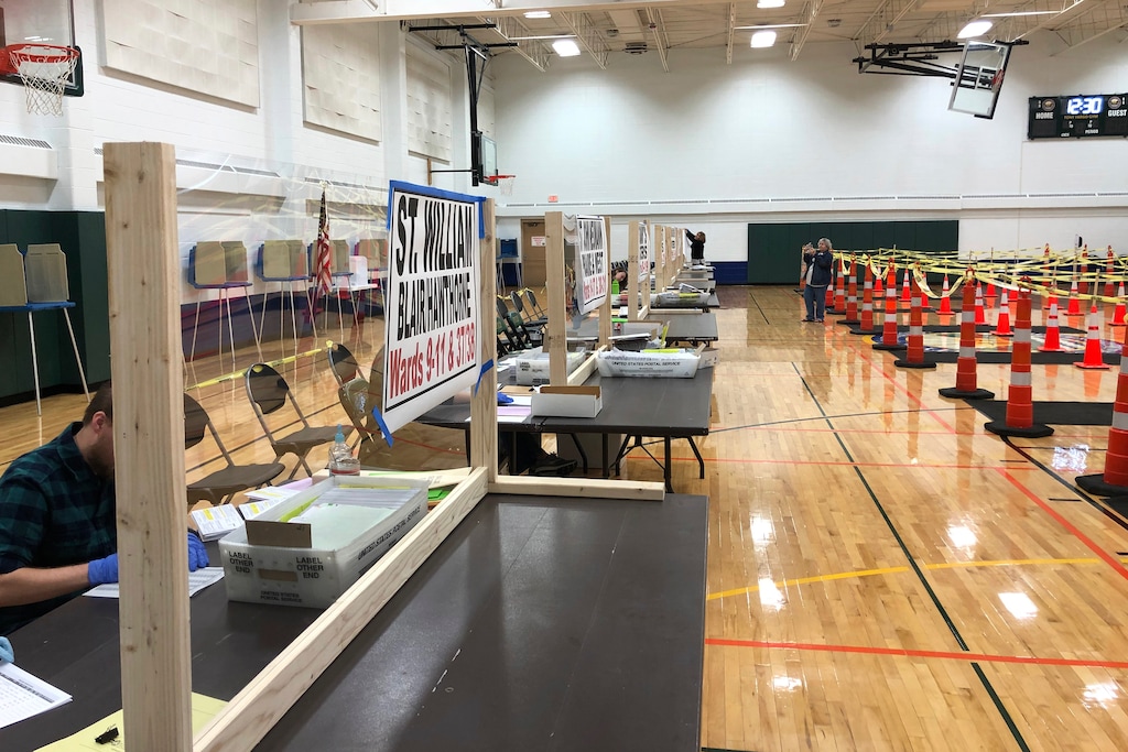 (Scott Trindl via AP)  A table is fitted with protective plexiglass at the sole polling location for city of Waukesha, Wis., residents, on April 6, 2020. Wisconsin Gov. Tony Evers on Monday, April 6, 2020 moved to postpone the state's presidential primary for two months because of the coronavirus pandemic, prompting a court challenge and adding to confusion about whether voters will be able to head to the polls on Tuesday.
