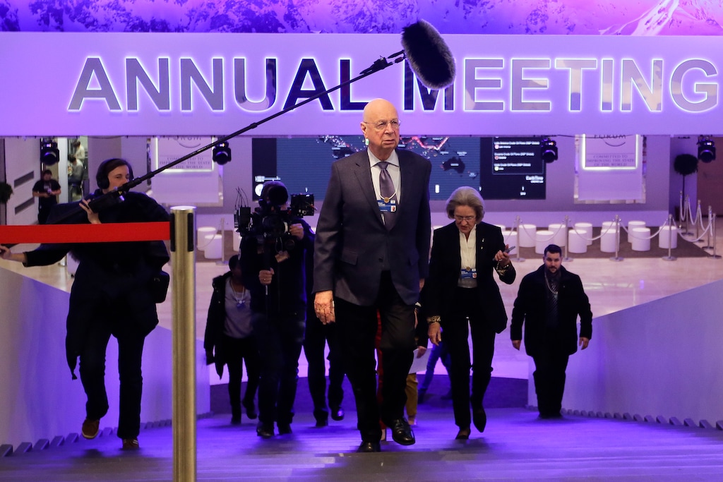 Followed by a television team and assistants Klaus Schwab, center, founder and Executive Chairman of the World Economic Forum, walks through the meeting's conference center in Davos, Switzerland, Sunday, Jan. 21, 2018. The meeting brings together entrepreneurs, scientists, chief executives and political leaders from Jan. 23 to 26. (AP Photo/Markus Schreiber)