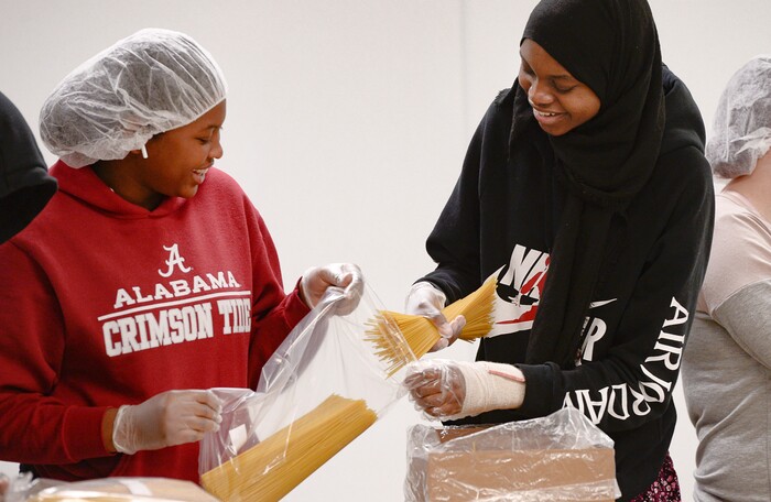 (Francisco Kjolseth  |  The Salt Lake Tribune) Aisyah Jammeh, left, and Halima Hassan, both members of YouthCity Government volunteer filling bags with pasta at the Utah Food Bank on Monday, Jan. 20, 2020, to celebrate the 2020 Martin Luther King Jr. Day of Service.