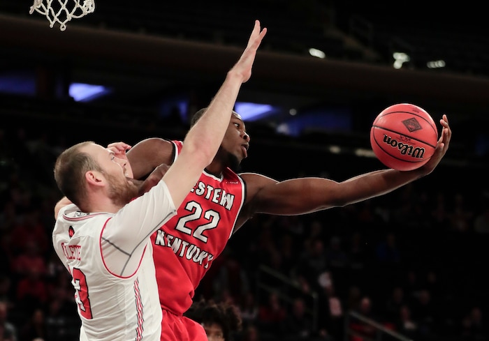 Western Kentucky forward Dwight Coleby (22) pulls down a rebound against Utah forward David Collette (13) during the first half of an NCAA college basketball game in the semifinals of the NIT, Tuesday, March 27, 2018, in New York. (AP Photo/Julie Jacobson)