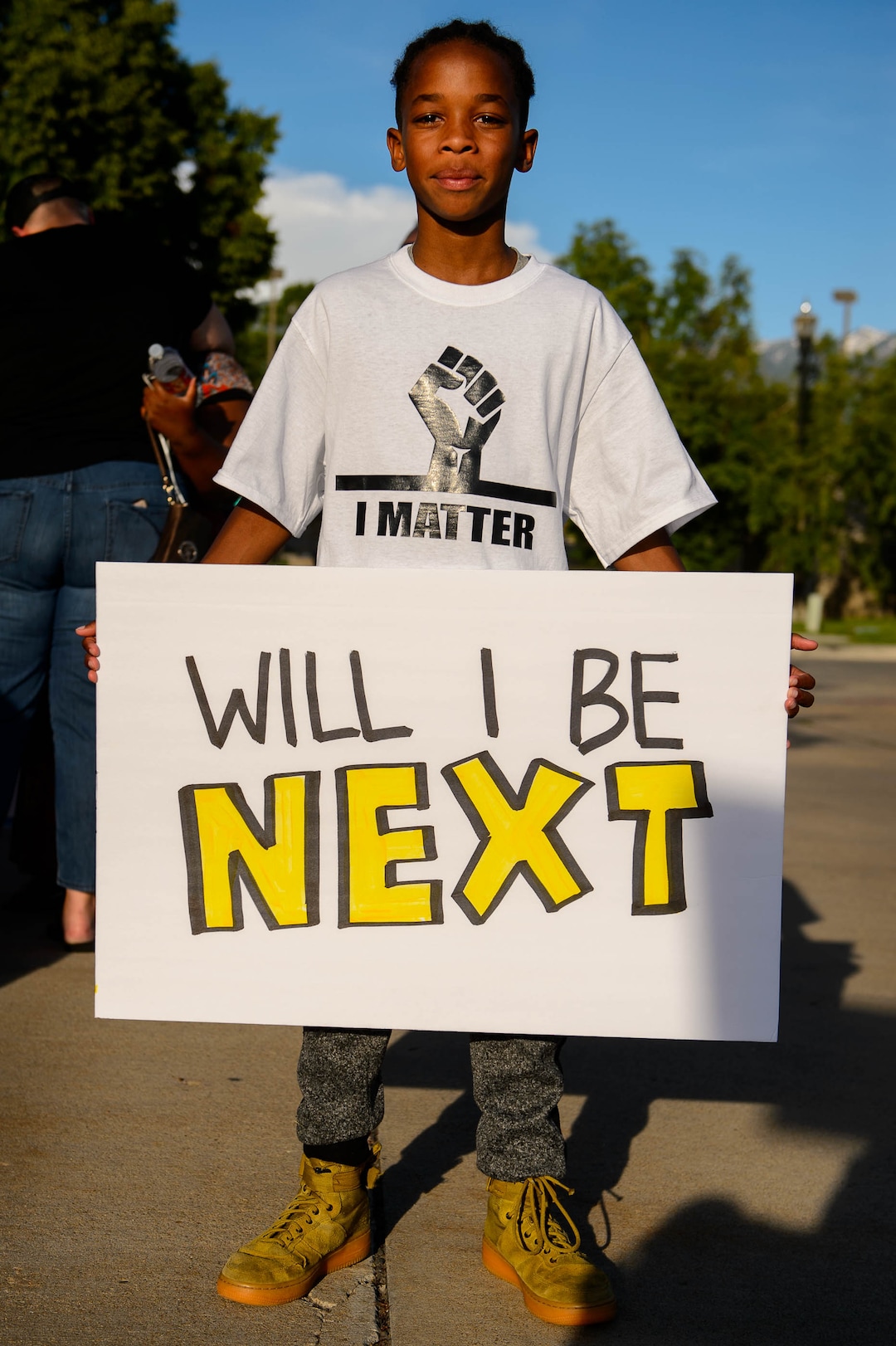 (Trent Nelson  |  The Salt Lake Tribune)Owen Burket, 11, holds a sign reading "Will I Be Next" at a protest organized by Black Lives Matter and other groups at the Woods Cross Police Department on Friday June 14, 2019. The rally was to show support for DJ Hrubes, a 10-year-old black child who was held at gunpoint by a police officer last week while playing in his grandmother's front yard.