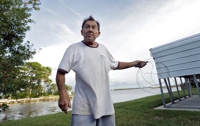 (Chris O'Meara | The Associated Press) Robert Sandousky gestures as he holds up some wire he plans on using to repair one of his fences from storm debris at his home Tuesday, Oct. 9, 2018, in Keaton Beach, Fla. Sandousky has ridden out several storms since he moved to the area some 40 years ago. Hurricane Michael continues to churn in the Gulf of Mexico heading for the Florida panhandle.