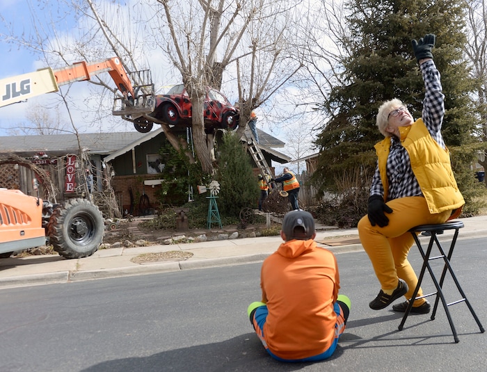(Al Hartmann | The Salt Lake Tribune)
Clearfield public works personnel use a crane to remove Janis Zettel's gutted VW Beetle from a tree in her front yard Tuesday Feb. 13. She put it up a few months ago as an art installation. Now it has to come down. Zettel watches the operation with her grandson Fischer Grant from the street.