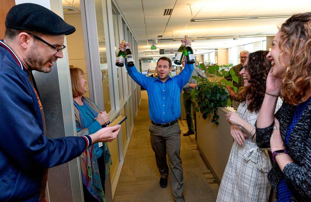 (Francisco Kjolseth | The Salt Lake Tribune) In this April 10, 2017, file photo, Salt Lake Tribune senior managing editor Matt Canham breaks out the Champagne after the staff's 2017 Pulitzer Prize for local reporting was announced, in Salt Like City. The Tribune newsroom takes up most of one floor of the building that bears its name, overlooking snow-capped mountains and the arena where the Utah Jazz play. Once a Digital First property that dealt with staff reductions and feared closure, the paper was sold to a prominent local family in 2016. Since then, its reporters received their first raise in a decade and won a Pulitzer Prize for investigative reporting.