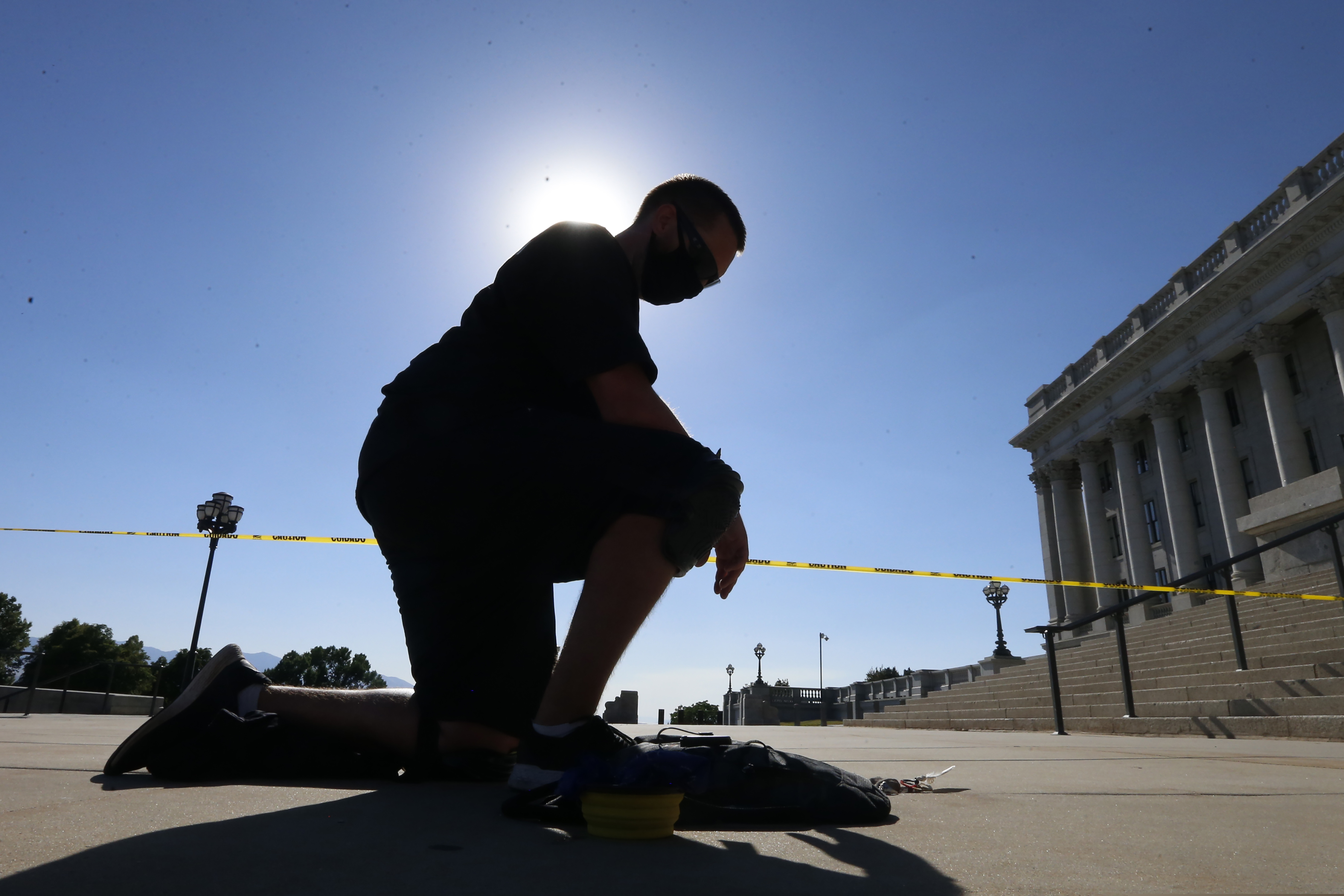 Shane Brooks, a Marine Corps veteran, kneels for nine hours outside the Utah Capitol to call attention to racial injustice, police brutality and mental health, Thursday, Aug. 6, 2020, in Salt Lake City. Brooks said people of color with mental illness are "looked at as if they have already committed a crime" and some end up dead in encounters with police, KTVX-TV reported. Brooks said his marathon silent protest was inspired by Bobby Duckworth, a 26-year-old who was shot and killed in 2019 by police responding to a report of a suicidal person in Wellington, Utah. (AP Photo/Rick Bowmer)