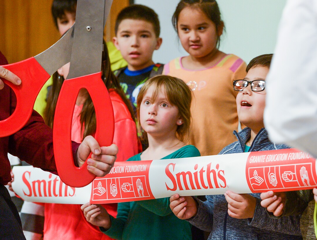 (Leah Hogsten  |  The Salt Lake Tribune) l-r The eyes of Ailie Spencer and Axel Godinez are as big as the ribbon cutting scissors, Tuesday, March 13, 2018 during a Smiths Food & Drug celebration and food pantry dedication at David Gourley Elementary School in Kearns, where 80 percent of the 646 students qualify for free or reduced lunches. 