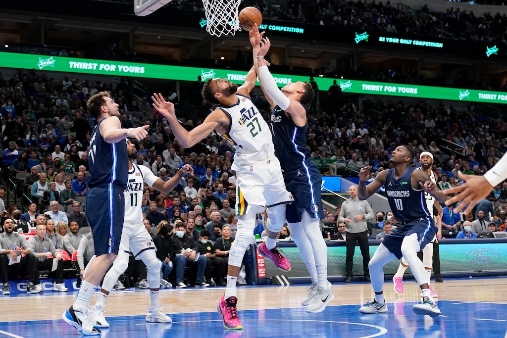 Utah Jazz center Rudy Gobert (27) blocks a shot-attempt by Dallas Mavericks center Dwight Powell, right, as Mavericks' Luka Doncic, left, looks on in the second half of an NBA basketball game in Dallas, Monday, March, 7, 2022. (AP Photo/Tony Gutierrez)