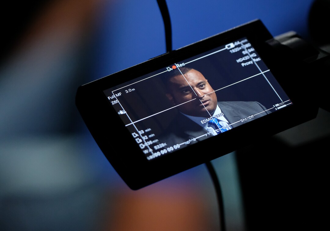 (Francisco Kjolseth  |  The Salt Lake Tribune)  BYU head football coach Kalani Sitaki sits for an interviews as he is projected on a cameraman's screen during BYU football media day at the BYU Broadcasting Building in Provo on Tuesday, June 18, 2019.