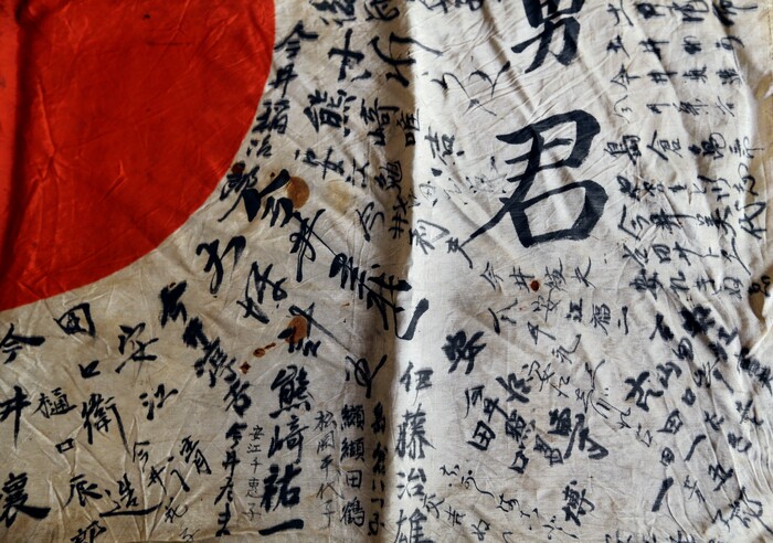 In this Monday, Aug. 7, 2017 photo, names are visible on a Japanese flag owned by WWII veteran Marvin Strombo in Portland, Ore. Strombo recovered the flag from a dead Japanese soldier in the Pacific more than 70 years ago and now, at age 93, will return the flag to the Japanese man's surviving siblings. (AP Photo/Don Ryan)