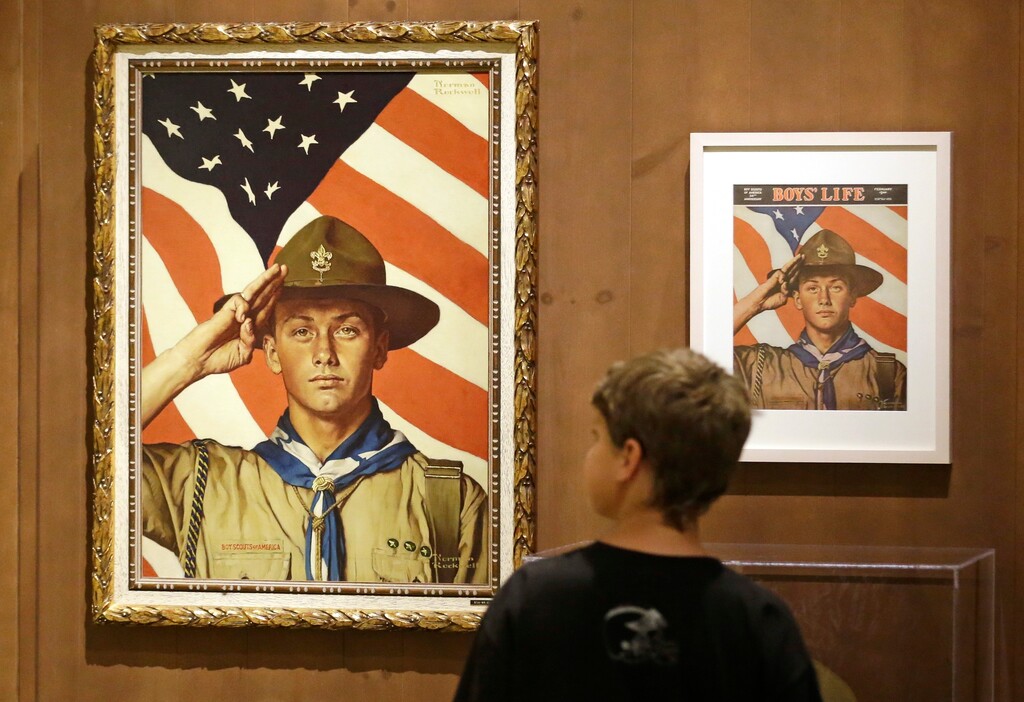 FILE - In this July 22, 2013, file photo, Andrew Garrison, 11, of Salt Lake City, looks over the Rockwell exhibition at the Mormon Church History Museum in Salt Lake City. Twenty-three original, Boy Scout-themed Norman Rockwell paintings were on display in Salt Lake City to celebrate the 100-year relationship between Scouting and the Mormon church. An announcement Tuesday night, May 8, 2018, by The Church of Jesus Christ of Latter-day Saints and Boy Scouts will mark an end to close relationship that lasted more than a century built on their shared values. The religion will move its remaining boys into its own scouting-type program. (AP Photo/Rick Bowmer, File)